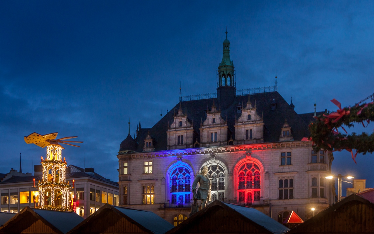 Rathaus in Halle (Saale) in der Abenddämmerung in den Farben der Tricolore angestrahlt.